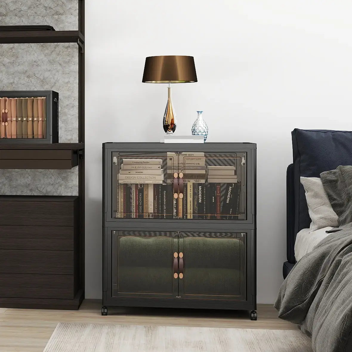 Black foldable storage cabinet with clear doors used as a nightstand between a wardrobe and bed